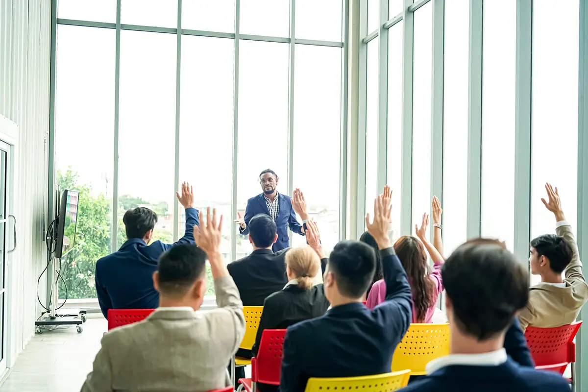 Business owners raising their hands during a MasterCLASS session