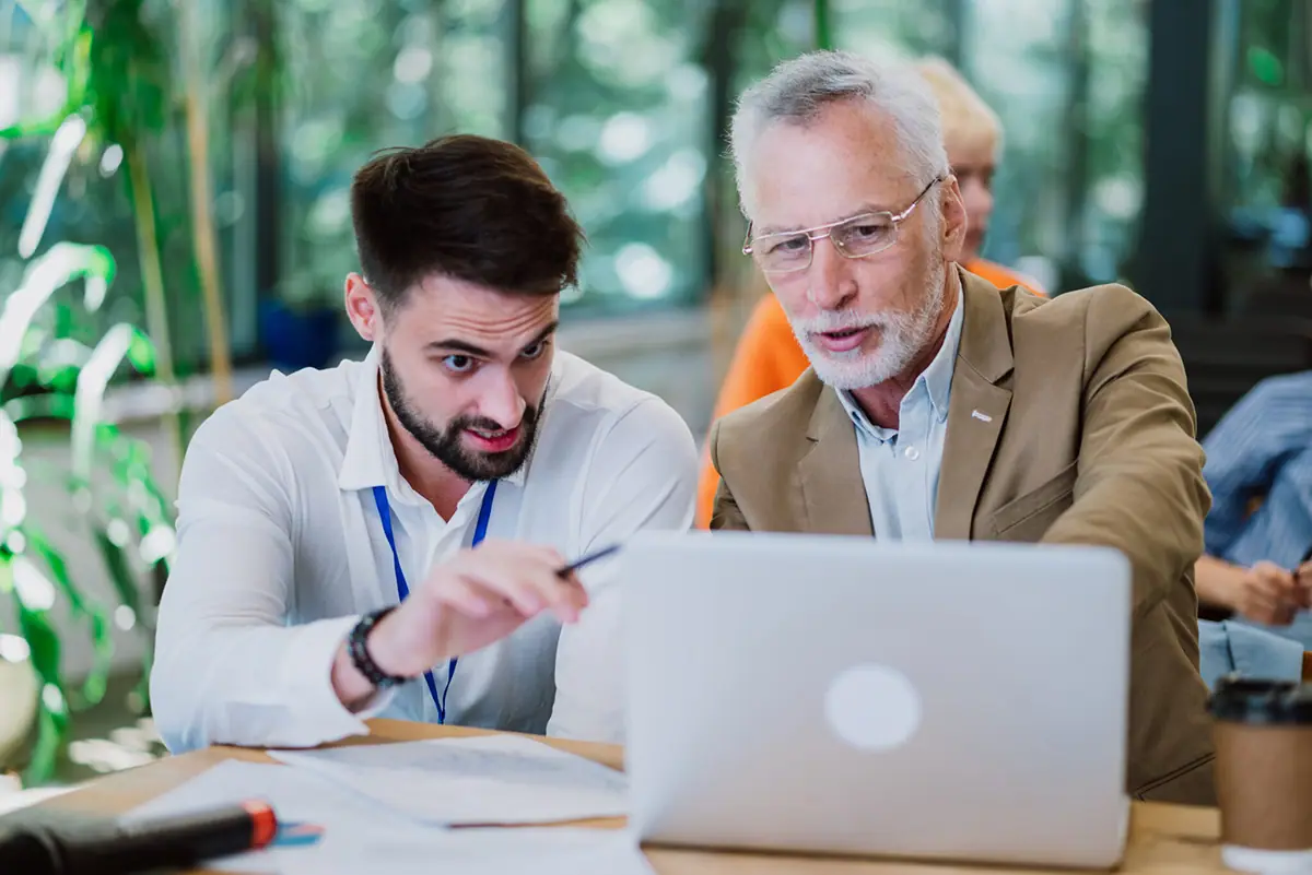 A business coach working through a plan with a business owner at a laptop